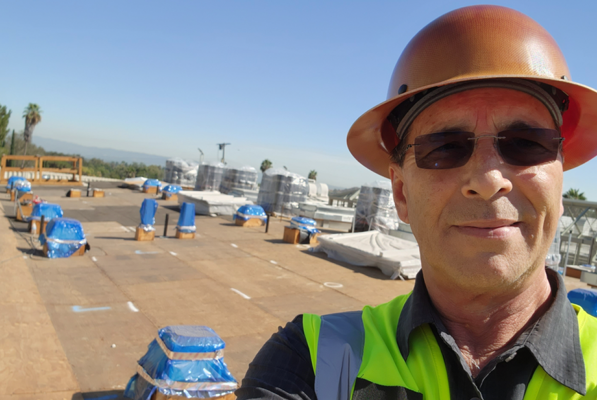 Construction worker on commercial roof in Southern California.