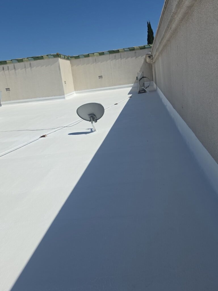 White commercial roof with satellite dish, clear blue sky