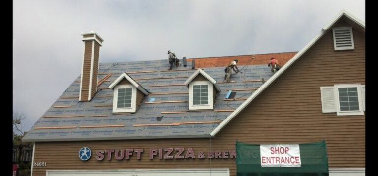 Roofers working on Stuft Pizza building in Dana Point.