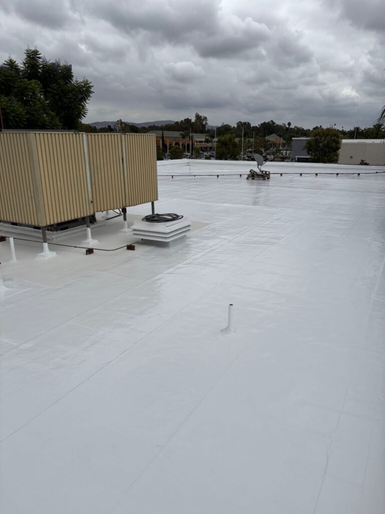 Commercial rooftop with HVAC units under cloudy sky.